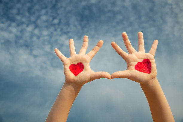 在天空的背景上画两个孩子的手和红心，复制空间图片下载