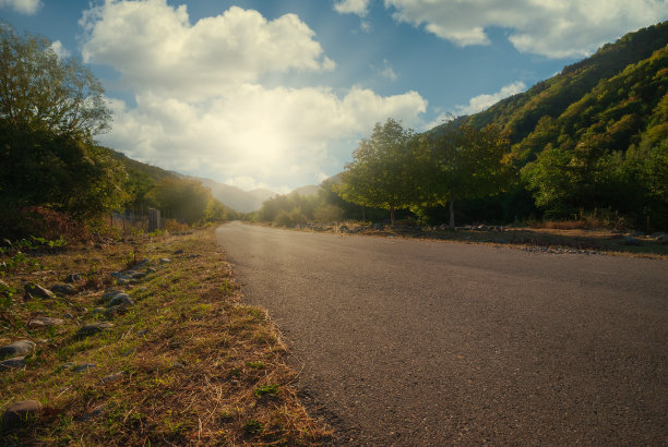 夏天的乡间小路，路旁有树。农村上山，环境大道。自然之路。沥青路面图片下载