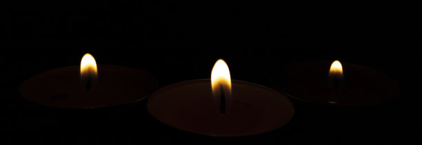 蜡烛的火焰孤立在黑色背景上。图片下载