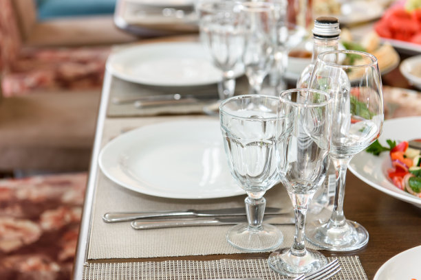 摆着玻璃杯和盘子的桌子。图片下载