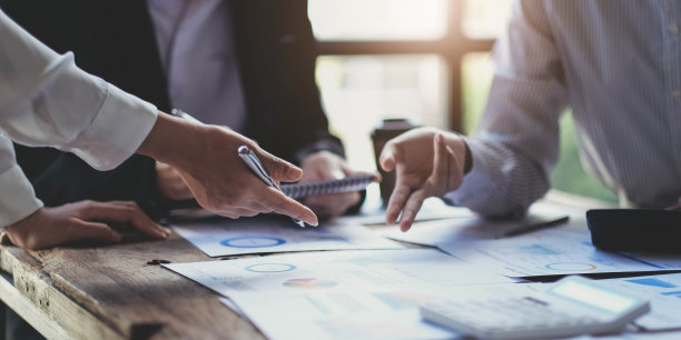 业务团队使用财务数据和报表图进行头脑风暴和讨论。团队会议工作理念。图片下载