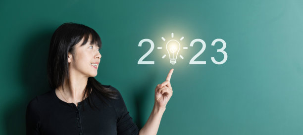 妇女指着黑板上2023年新年的文字图片下载