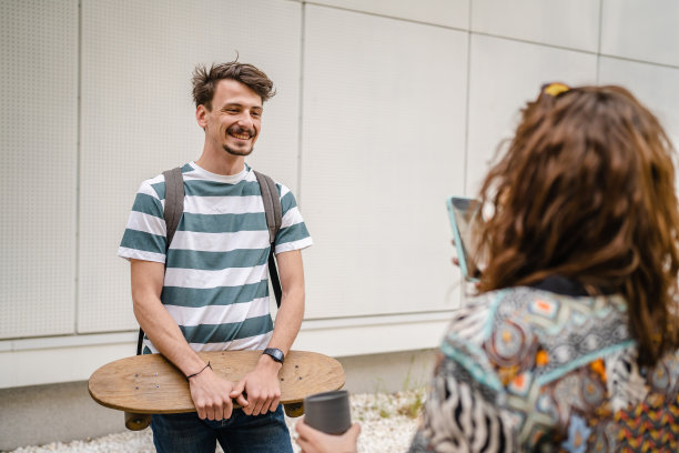 一名男子和他的女友用智能手机给他拍照图片下载