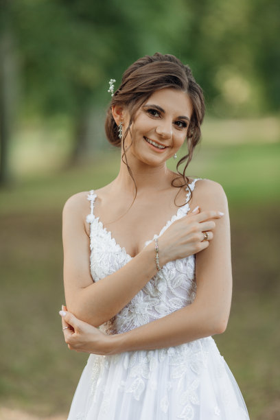 画像好看的女人美丽的发型，黑色的头发穿着白色的连衣裙，站在公园在夏天。图片下载