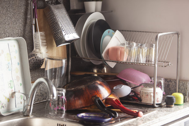堆着用过的煎锅，水槽里装满了洗过的厨房用具图片下载