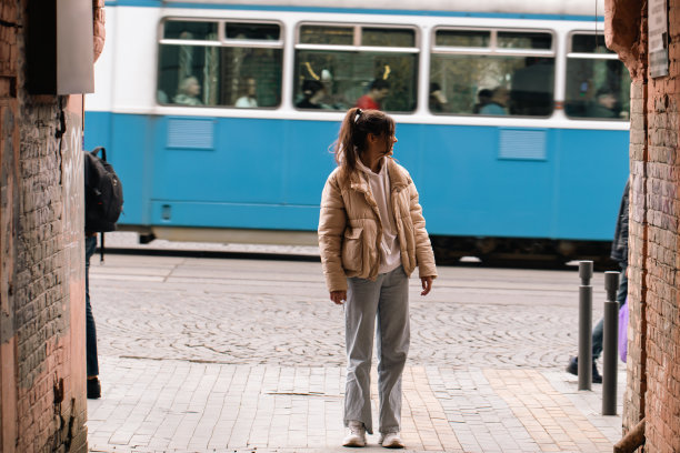 一个女人走在城市的街道上，一个从巷子里看到的风景，一个偶然路过的人。图片下载