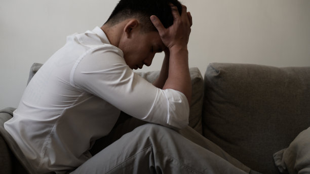 接近年轻的亚洲男子感到不安，悲伤，不高兴或失望哭泣孤独在他的房间。青少年心理健康心理问题概念。图片下载