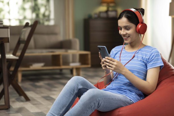 年轻女子在家里听音乐，库存照片图片下载