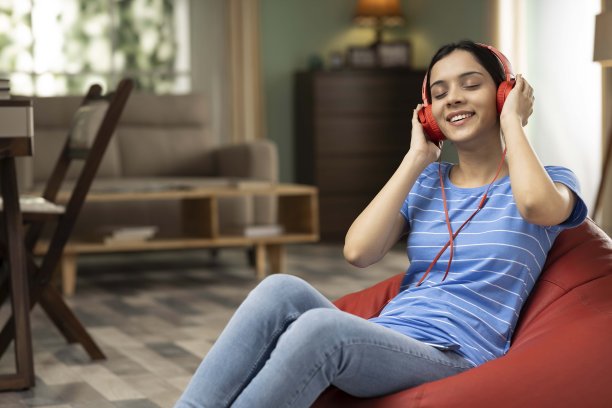年轻女子在家里听音乐，库存照片图片下载