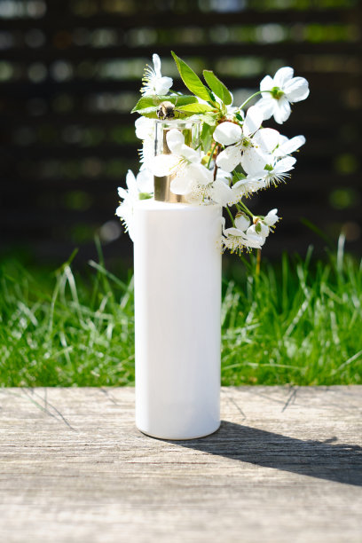 瓶瓶罐罐的化妆品霜、凝胶或乳液，以大自然和花朵为背景。介绍化妆品的背景。空白标签的品牌模型。皮肤护理的概念图片下载