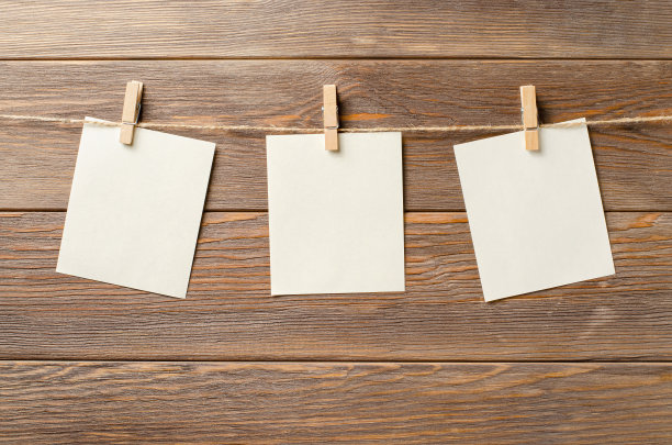 空纸挂在绳子上。一个设计元素。布朗木制背景。副本的空间。图片下载