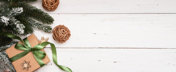 生态圣诞假期背景。圣诞树，手工纸礼品盒，礼物，木制装饰。圣诞灯。横幅。图片下载