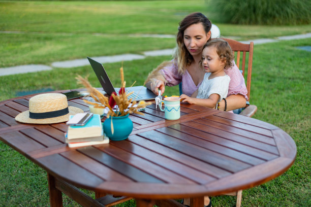 那位妇女一边工作一边和她的孩子玩耍。图片下载
