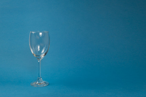 蓝色背景的空玻璃杯，葡萄酒玻璃杯，晚餐和派对的概念。图片下载