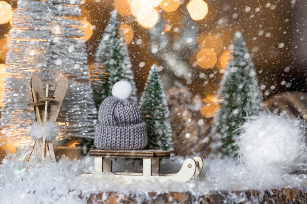 2023年新年快乐。美丽的背景有蜡烛，一个带针织帽子的雪橇，圣诞树和装饰品。庆祝冬季圣诞假期。年初的概念。图片下载