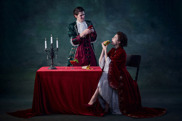 肖像的男人和女人的形象吸血鬼在深绿色的背景。男子自拍女子吃汉堡图片下载