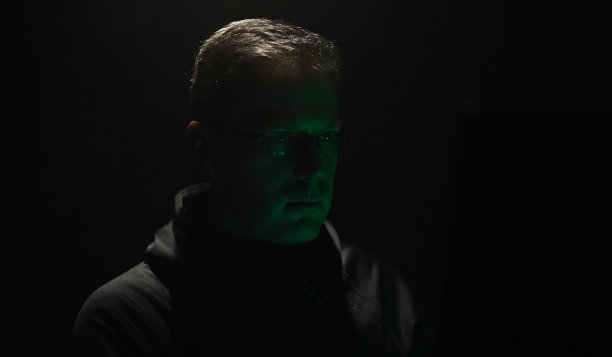 穿着卫衣的人在电脑上工作。图片下载