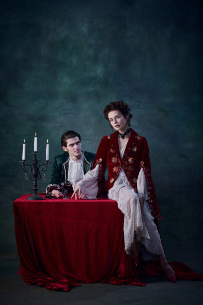 神奇的女人和男人的肖像，吸血鬼在中世纪服装在深绿色的背景。喝血图片下载