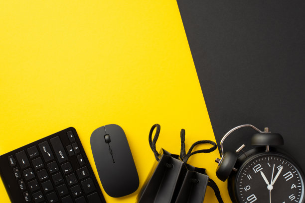星期一的概念。俯视图照片键盘，电脑，鼠标，黑色纸袋和闹钟双色黄色和黑色背景与copyspace图片下载