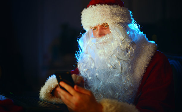 圣诞老人正在用手机。图片下载