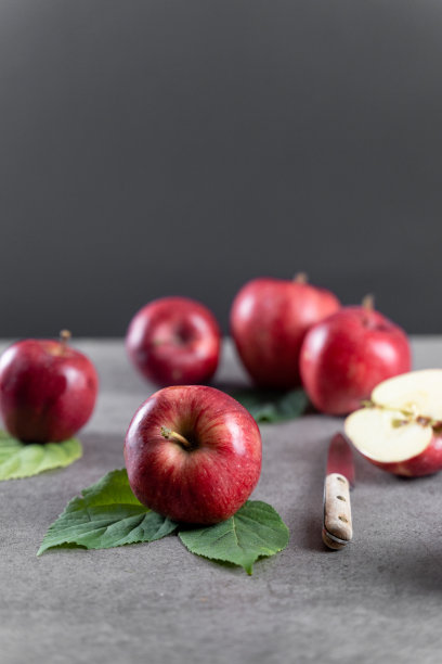 成熟的苹果在石头桌上，前视图，灰色背景与复制空间和选择性聚焦在前面图片下载