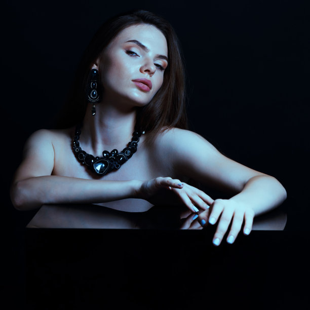 美丽的女人与花哨的项链和耳环工作室肖像图片下载