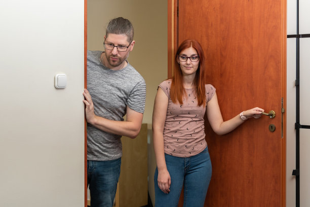 一个红头发的女孩和一个男人正在看她的新宿舍，有复印空间图片下载