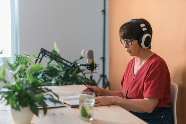 中年妇女电台主持人为在线节目制作播客录音-广播和dj的概念图片下载