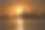 夕阳映照在水中的城市天际线剪影。图片下载