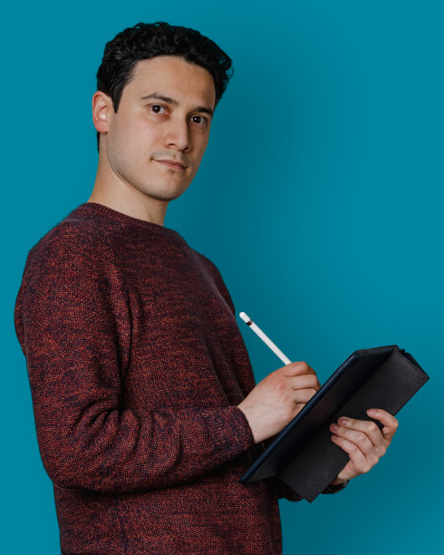 男子在蓝色背景上使用平板电脑和电子笔图片下载