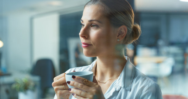 在办公室喝着咖啡的思维女性，专注于机会，目标和愿景的梦想。年轻的企业专业人士在茶歇时记得想法，解决方案和计划图片下载