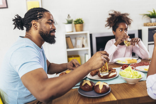 一个多代非裔美国家庭在餐桌上享受美食。图片下载