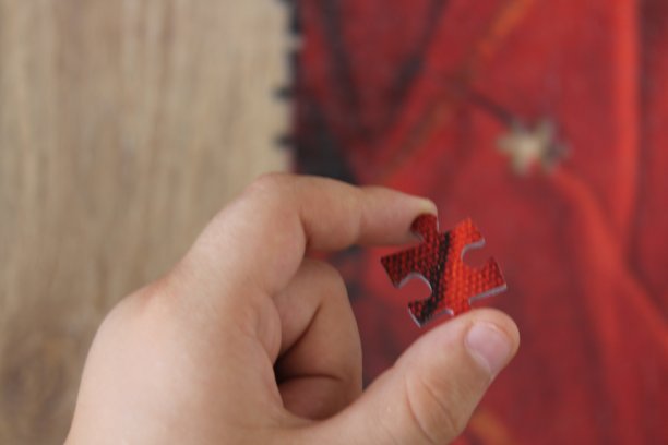 拼图的概念的想法。拼图块，一个男孩拿着红色的拼图块把它放好。图片下载