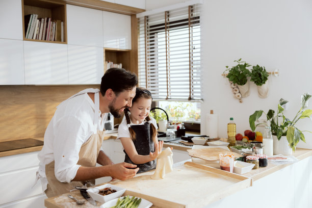 好奇的女儿小孩想用手滚面团。父亲看着过程管理。快乐的父母周末花时间和女儿准备自制披萨图片下载