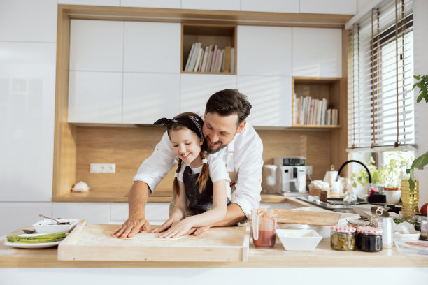 高兴的父亲与熊花时间与小女儿教学，揉面，用手擀面，烹饪，烘焙，为可爱的母亲准备惊喜图片下载
