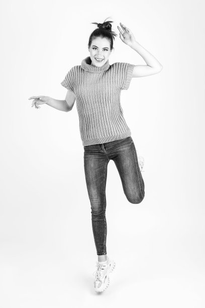 穿着蓝色无袖毛衣和蓝色牛仔裤的漂亮女人图片下载