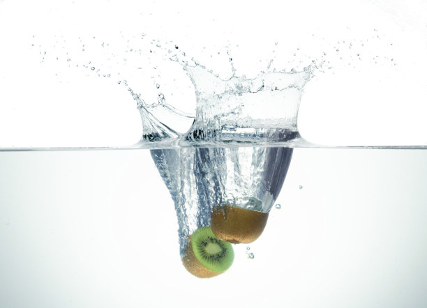 两个半猕猴桃在水里飞溅。图片下载