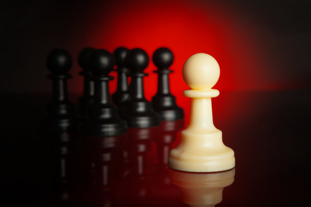 国际象棋棋子在深色背景与红色背光接近图片下载