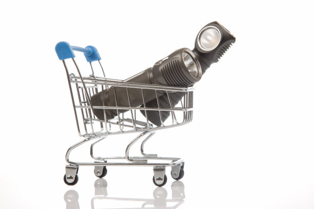 白色背景的购物篮里放着不同的手电筒。销售和购买露营和家庭用品。图片下载