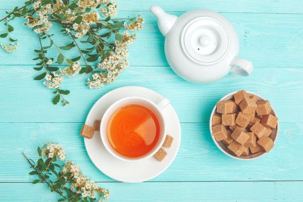 用陶瓷杯盛绿茶，配上盛开的树枝图片下载