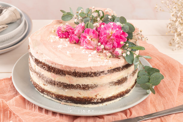 巧克力裸蛋糕，白色背景上有新鲜玫瑰和瑞士奶油图片下载