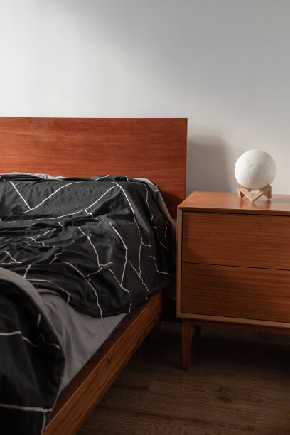 卧室有一张木床和床头柜，被子和一盏灯，家具图片下载