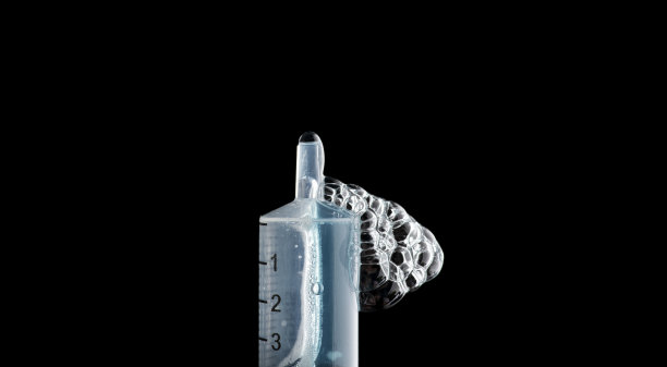 医用注射器在注射器的压力下喷出液体，有气泡和滴水图片下载