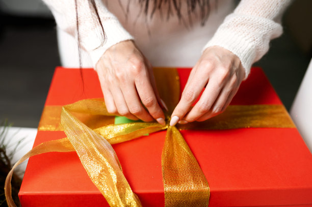 女人的手解开礼物包装图片下载