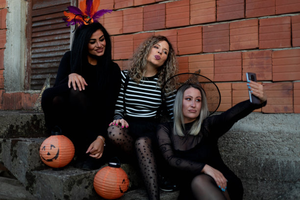 女人们坐在古老的混凝土台阶上自拍。图片下载