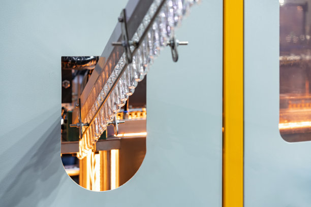 在饮料工业中，许多预成型的塑料pet清料在运输过程中由斜挂式输送机输送到自动制造工艺的水瓶吹制图片下载