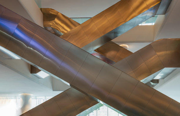 复杂的内部侧视图多个现代化自动扶梯。交错的自动扶梯。图片下载