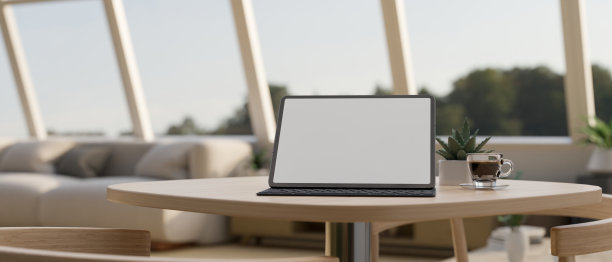 便携式平板样机在舒适和最小的咖啡店最小的木桌。图片下载