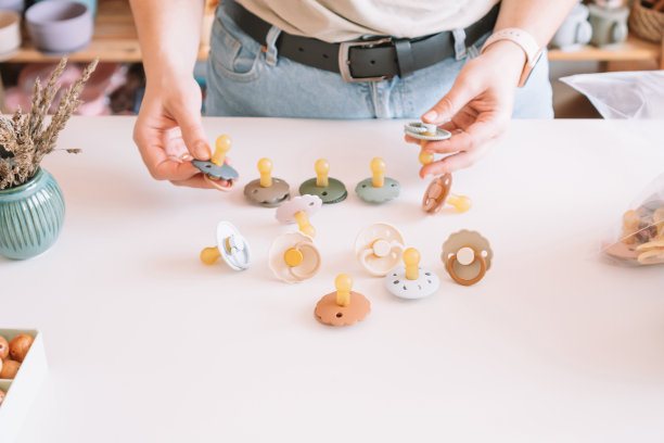 裁剪商业女性的手，制作和设计工艺硅胶安抚新生儿。自然生态配件图片下载