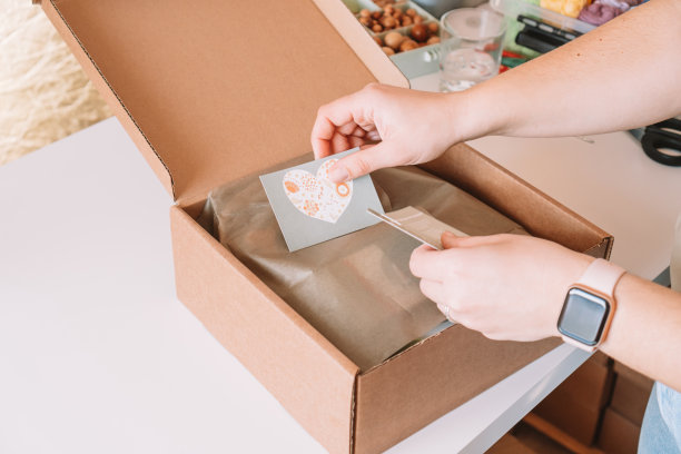 裁剪的照片，女商人的手包装，准备包裹交付包的买家，把明信片的盒子图片下载